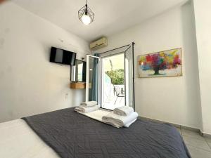 a bedroom with a bed with towels on it at Enjoy Parga Appartments in Parga