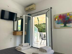 a bedroom with a sliding glass door to a patio at Enjoy Parga Appartments in Parga +40 photos