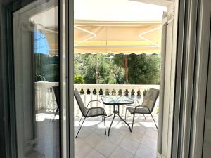 a patio with a table and chairs on a balcony at Enjoy Parga Appartments in Parga