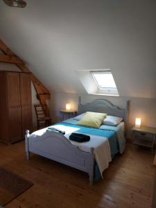 a bedroom with a bed and a skylight at Gîte Baumelin près de Dinan in Guenroc