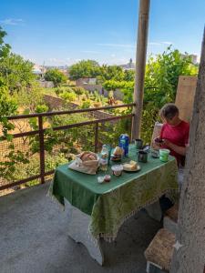a man sitting at a table with a green table cloth at Chinese home in Masis