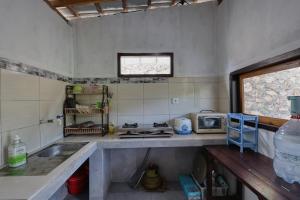 a kitchen with a sink and a counter top at Kapouk Cottage in Nusa Penida
