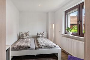 a white room with two beds and a window at Fewo Drei Gleichen Nr 2 in Wandersleben