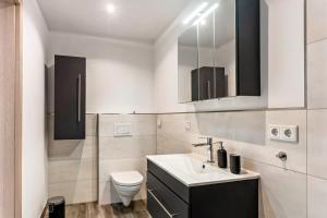 a white bathroom with a sink and a toilet at Fewo Drei Gleichen Nr 2 in Wandersleben