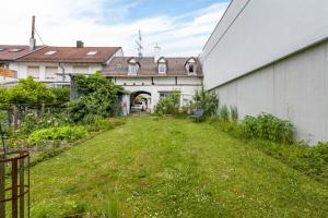 an empty yard next to a white building at Large Apartment 60 M² With Garden in Emmendingen