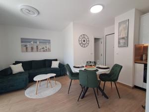 a living room with a couch and a table and chairs at Luxury Mint Garden Apartment in Kaštela