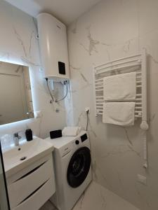 a bathroom with a washing machine and a sink at Luxury Mint Garden Apartment in Kaštela