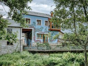 a house with a painting on the side of it at Aida's Hostal in Puentes de García Rodríguez