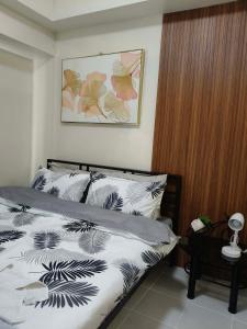 a bedroom with a bed with black and white sheets at Maldee's Place Tagaytay Prime Residences in Tagaytay +16 photos