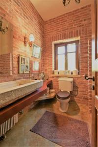 a bathroom with a brick wall and a toilet and a tub at The Seacret Beachfront Villa in Nea Peramos +41 photos