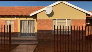 a house with a fence in front of it at The Pebbles-Unit-1 in Mahikeng