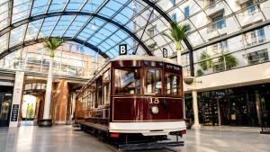 a trolley car in a building with a glass ceiling at Cathedral Junction Apartments in Christchurch