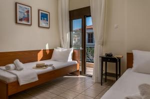 a bedroom with two beds and a door to a balcony at Kripis Studio in Pefkochori