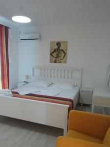 a bedroom with a white bed and a chair at Sea View 3-Room Apartment in Olimp