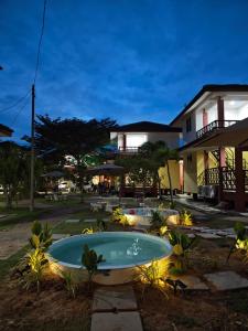 a backyard with two pools and a house at Chalet Kurung Tengar in Kuala Perlis
