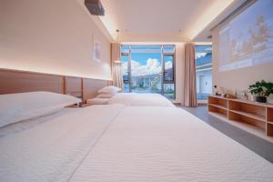 a bedroom with two beds and a large window at Zhangjiajie The Brookside Hotel& Tianmen National Forest Park & Free pick up service in Zhangjiajie +74 photos