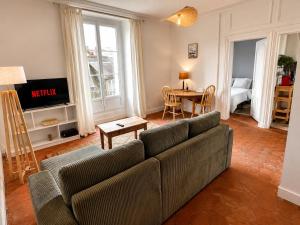 a living room with a couch and a table at Charmant 2 pièces - centre historique - Vieux Mans in Le Mans