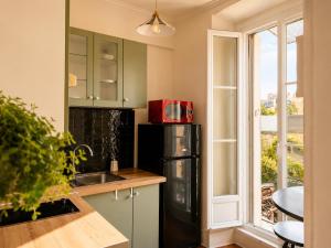a kitchen with a black refrigerator and a window at Charmant 2 pièces - centre historique - Vieux Mans in Le Mans