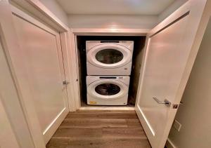 a washer and dryer in a small closet at The Classic Suite: 2BR close to NYC in Paterson
