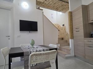 a dining room with a table and a tv on the wall at Perla -Centro Storico Vasto- in Vasto