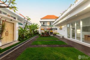 an empty courtyard of a house with green grass at Made's Dream Villa Amed in Amed