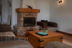 a living room with a brick fireplace and a coffee table at La Perla Villa del Lago in Paloznak