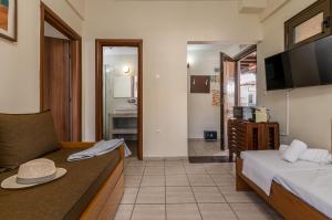 a hotel room with two beds and a television at Kripis Studio in Pefkochori