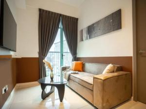 a living room with a couch and a table at Liwan, Baysuite by Ayuhouz in Kota Kinabalu