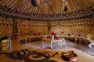 an interior view of a yurt with tables and shoes at Kurjun Guest House in Bokonbayevo +50 photos