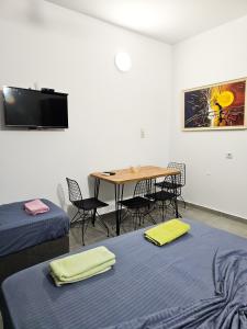 a room with two beds and a table with chairs at Klea Rooms in Velipojë
