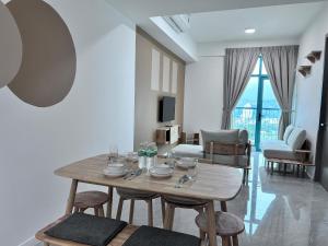 a living room with a wooden table and chairs at Liwan, Baysuite by Ayuhouz in Kota Kinabalu
