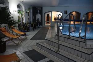 a swimming pool in a building with chairs and a swimming pool at Fewo Seeanker in Friedrichskoog