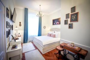 a bedroom with a white bed and a chandelier at Casa Baritiu Rooms in Braşov