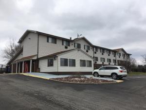 a white car parked in front of a building at Super 8 by Wyndham New Castle in New Castle