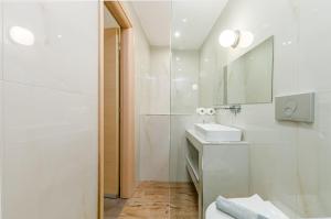 a white bathroom with a sink and a mirror at Kripis Studio in Pefkochori +87 photos