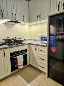 a kitchen with a stove and a refrigerator at Entire Space T3 Centralidade do Kilamba, Luanda in Luanda