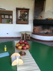 a table with a plate of fruit on a table with a fireplace at Bosque Macadamia in El Tejar