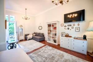 a living room with a couch and a tv on the wall at Casa Baritiu Rooms in Braşov