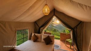 a bedroom in a tent with a bed and a window at COCO FOREST CAMPING - Luxury Glamping & Villa - ONLY FOR FOREIGN BOOKINGS in Kurunegala
