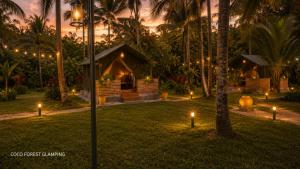 a night view of a resort with lights in the grass at COCO FOREST CAMPING - Luxury Glamping & Villa - ONLY FOR FOREIGN BOOKINGS in Kurunegala