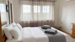 a bedroom with a white bed with pillows and a window at Villasobota in Rimavská Sobota +18 photos