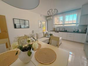 a kitchen and living room with a table with flowers on it at Whitealcyone Fit & Zen Apartment in Artemida