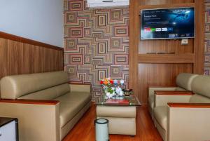 a living room with a couch and a tv at Balcony Superior King - Châu Giang Hotel in Ga Phú Trung