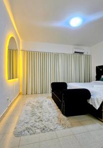 a bedroom with a bed and a couch and a rug at Entire Space T3 Centralidade do Kilamba, Luanda in Luanda