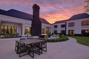 a building with a table and chairs in front of it at DoubleTree by Hilton Hotel Detroit Novi in Novi