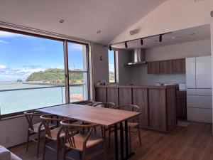 a kitchen with a table and chairs and a large window at Villa JacoO 2 in Sanuki +32 photos