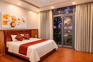 a bedroom with a bed and a large window at Balcony Superior King - Châu Giang Hotel in Ga Phú Trung
