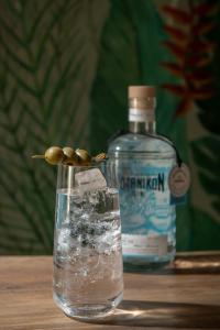 a bottle of gin sitting next to a glass of water at Riviera Boutique Hotel in Stalís