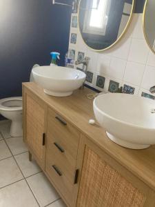 a bathroom with two sinks on top of a wooden cabinet at Chambre sympa in La Chapelle-sur-Erdre