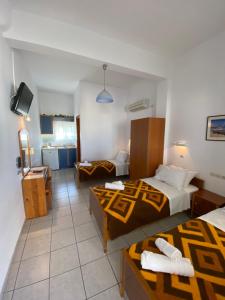 a hotel room with two beds and a television at Hotel Helena in Ios Chora